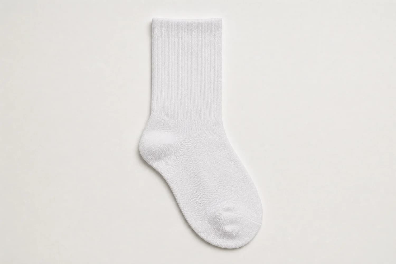 A white sock laid out flat and square on a plain sheet, the whole sock inside the frame with even margin.